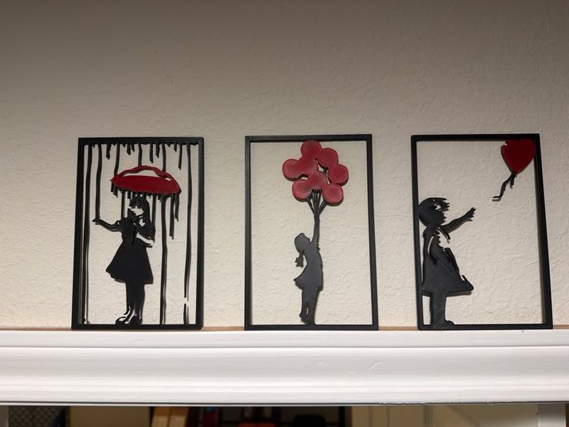 Three 3D-printed wall art panels showing a girl reaching for a balloon