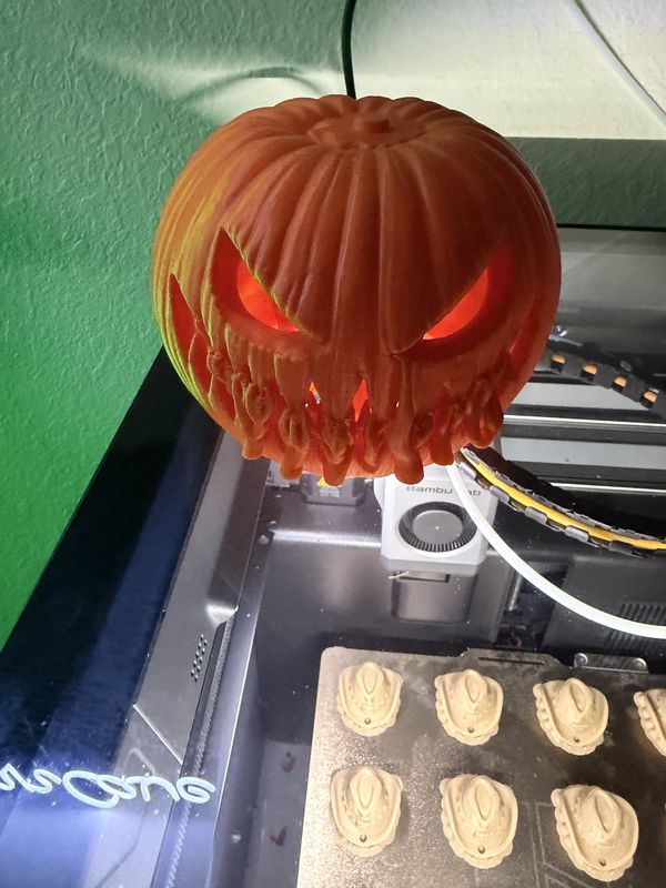 Orange 3D-printed jack-o-lantern lit from inside